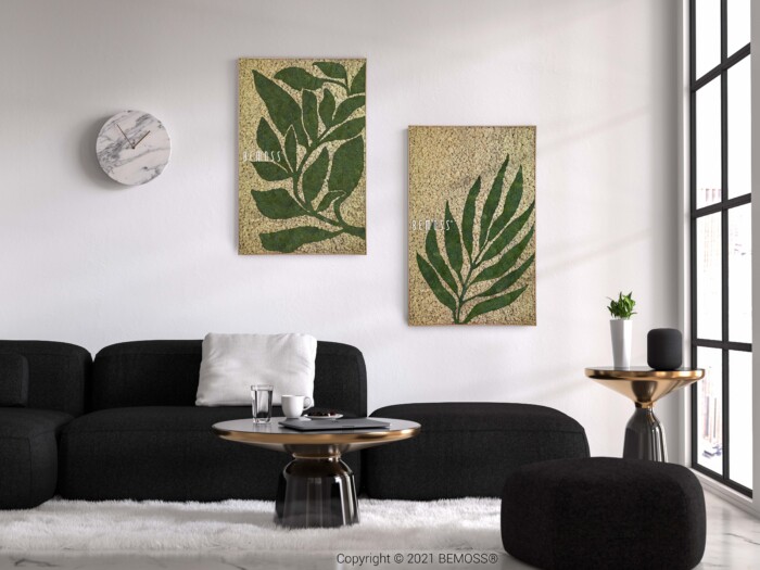 Un salon moderne présente un canapé noir, une table basse ronde avec plateau en verre, une petite table d'appoint ronde et un pouf noir. Deux grandes œuvres d’art encadrées de plantes vertes feuillues sont accrochées au mur au-dessus du canapé. Une horloge en marbre blanc et noir est également fixée au mur, complétant l'élégant Earth Rochoso.