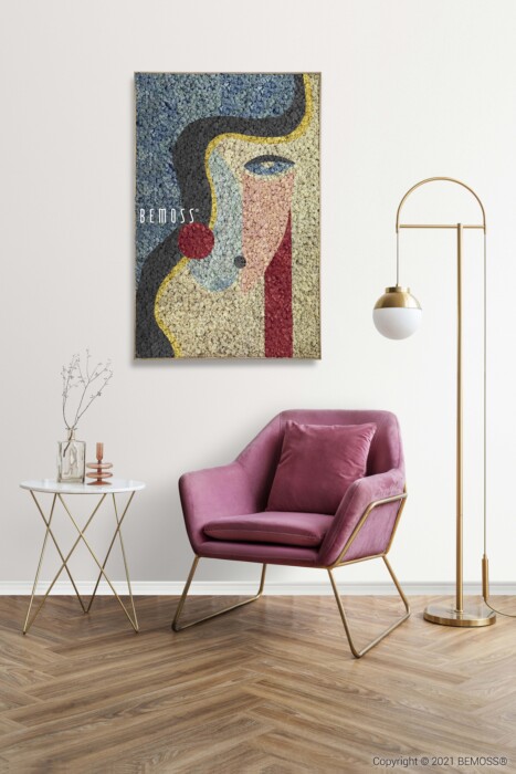 Un espace de vie confortable et moderne comprend un fauteuil rose moelleux avec des pieds dorés adjacent à une petite table d'appoint blanche avec un mince cadre doré. Un lampadaire haut et élancé fournit de la lumière et une œuvre d'art abstraite colorée intitulée 