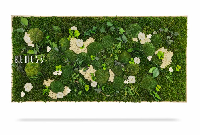 Une décoration murale rectangulaire en mousse verte avec des taches de différentes textures de mousse et des fleurs blanches. Le mot « BEMOSS » est affiché sur le côté gauche de ce Tableau de mousse PLANTES Mesia Natural. Le fond est blanc et il y a une ombre sous l’œuvre, lui donnant un aspect tridimensionnel.