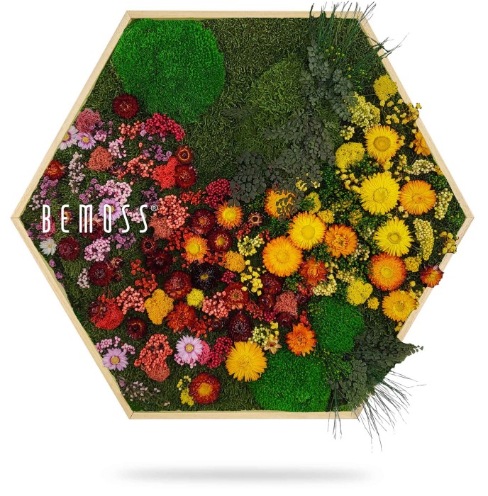 Une œuvre d'art murale hexagonale présentant une variété de fleurs et de plantes artificielles vibrantes disposées dans un dégradé allant du rouge et du violet au jaune et au vert. Le mot « BEMOSS » est imprimé sur le côté gauche de l’œuvre, encadré de bois clair, ressemblant à d’élégants murs en mousse.