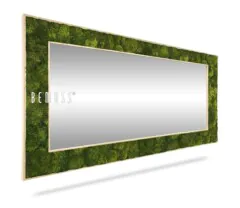 Un miroir rectangulaire élégant et moderne avec un cadre en mousse verte luxuriante et en bois de couleur claire est exposé sous un angle. Le nom de la marque « BEMOSS » apparaît sur le côté gauche du cadre, reflétant magnifiquement la lumière.